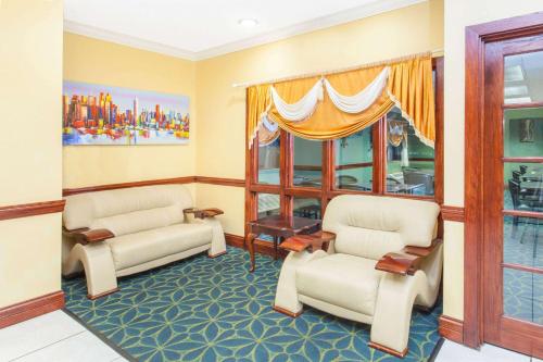 a waiting room with two chairs and a window at Ramada Limited Decatur in Forsyth