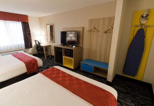 a hotel room with two beds and a television at Ramada Limited Decatur in Forsyth