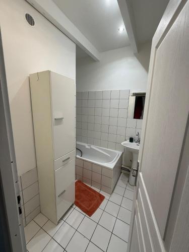 une salle de bain blanche avec une baignoire et un lavabo dans l'établissement Maison proche du centre, à La Rochelle