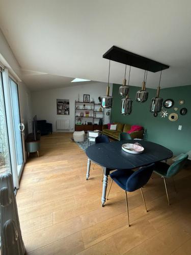 un salon avec une table et des chaises noires dans l'établissement Maison proche du centre, à La Rochelle