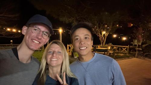 three people posing for a picture at night at Pea homestay in Sa Pa