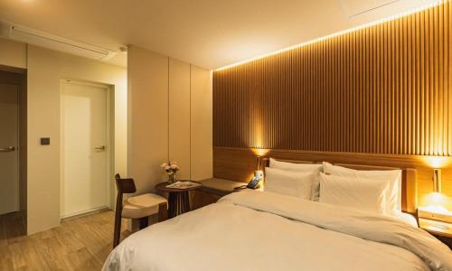 a bedroom with a large white bed and a desk at Hound Hotel chuncheon in Chuncheon