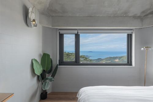 a bedroom with a window with a view of the ocean at Jiufen The Ocean Theory in Jiufen