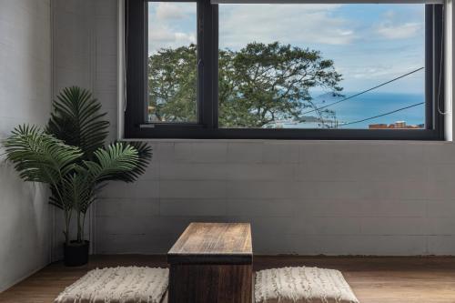 a bench and a plant in a room with a window at Jiufen The Ocean Theory in Jiufen