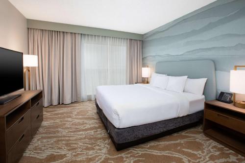 a hotel room with a bed and a flat screen tv at Embassy Suites San Marcos Hotel Conference Center in San Marcos
