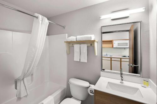 a bathroom with a white toilet and a sink at Birch Hill Suites Rochester - Med City in Rochester