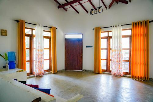 an empty room with a door and windows at Palm & Wild Hiriketiya in Dickwella