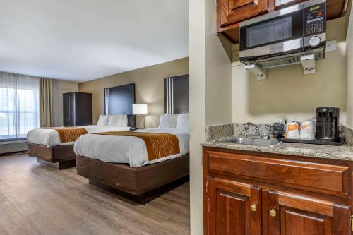 a hotel room with two beds and a kitchen with a sink at Comfort Inn near Downtown & Blue Ridge PKWY in Marion