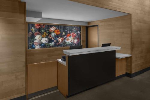 a reception desk in a lobby with a painting on the wall at Cambria Hotel New York - Chelsea in New York