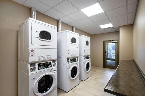 a laundry room with three washer and dryer machines at MainStay Suites Madison - Monona in Madison