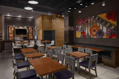 une salle à manger avec des tables et des chaises en bois dans l'établissement Cambria Hotel New York - Chelsea, à New York