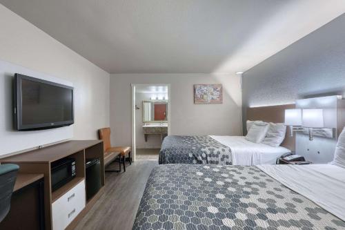 a hotel room with two beds and a flat screen tv at Econo Lodge Neenah in Neenah