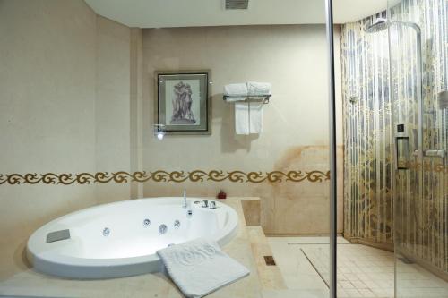 a bath tub in a bathroom with a shower at Chateau Star River Shanghai Minhang in Shanghai