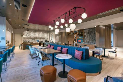 a restaurant with a blue couch and tables and chairs at Home2 Suites By Hilton Lumberton in Lumberton