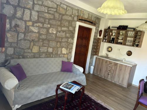 a living room with a couch and a stone wall at Sea forever in Petrovac na Moru