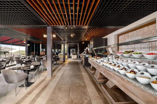 a restaurant with a buffet line with plates of food at Ramada by Wyndham Fethiye Oludeniz in Oludeniz