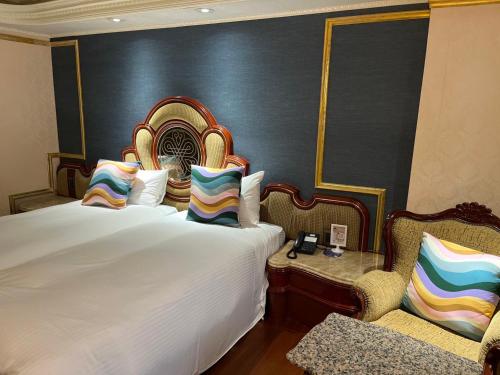 a hotel room with a bed and a chair at Happiness Hotel in Taipei