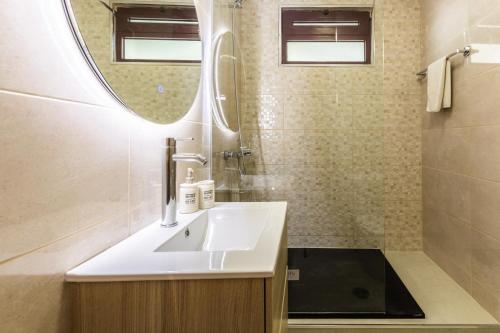a bathroom with a sink and a mirror at Calandiva in Caniço
