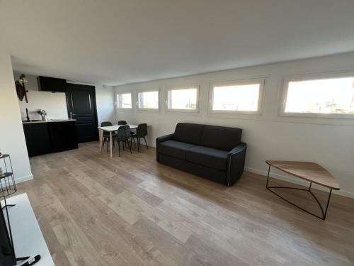 un salon avec un canapé noir et une table dans l'établissement Le Calais Wilson 4, 2-4 Pers, à Calais