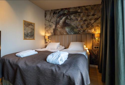two beds in a bedroom with a painting on the wall at Scandic Arvika in Arvika