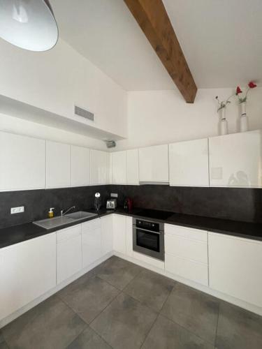 une cuisine blanche avec un évier et une cuisinière dans l'établissement L'ecrin de Thau, à Marseillan