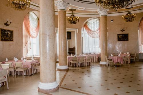 un salón de banquetes con mesas y sillas rosas en INTOURIST Hotel, en Volgograd