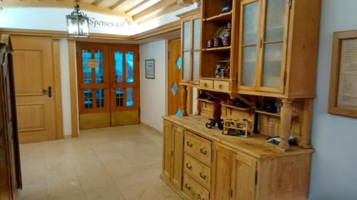 a large kitchen with wooden cabinets and a hallway at Hotel Unterwirt in Eggstätt