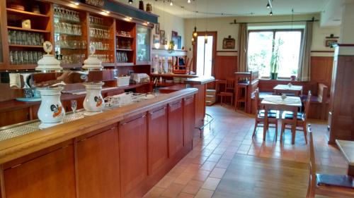 un ristorante con un bar con tavoli e sedie di Hotel Unterwirt a Eggstätt