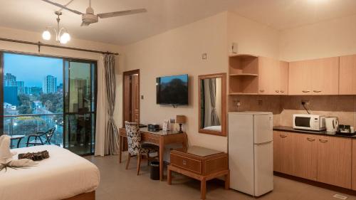 a room with a kitchen and a bed and a refrigerator at Lotos Inn & Suites, Nairobi in Nairobi