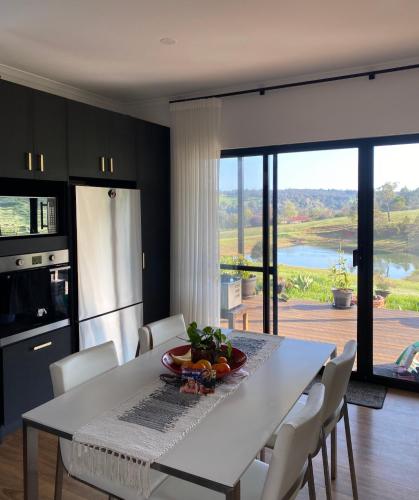 a kitchen with a table and chairs and a large window at Circle of Light Retreat in Kangaroo Gully