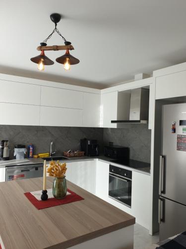 una cucina con armadi bianchi e un tavolo di S Villa City a Çeşme