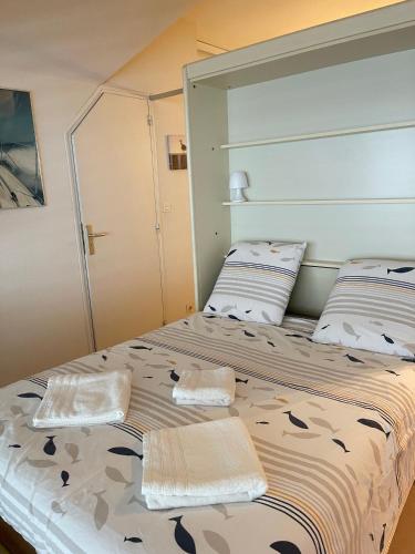 une chambre avec un grand lit avec deux oreillers dans l'établissement Plaisance, à Granville