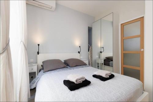 une chambre avec un lit blanc avec des serviettes dessus dans l'établissement 1 bed, center of Nice with AC, à Nice