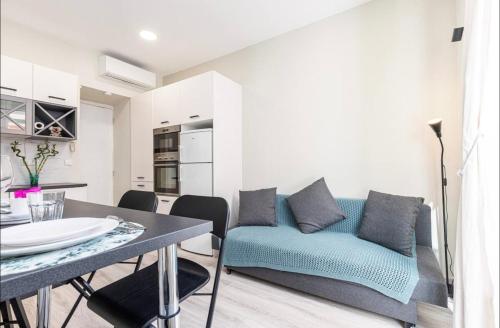 un salon avec un canapé bleu et une table dans l'établissement 1 bed, center of Nice with AC, à Nice