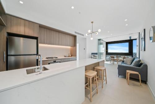 a kitchen and living room with a counter and a couch at Brand new Luxurious 1 Bedroom Perth CBD in Perth