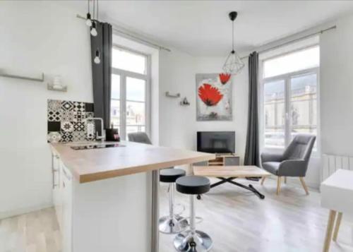 une cuisine et un salon avec une table et des chaises dans l'établissement Basilique VII, à Douvres-la-Délivrande