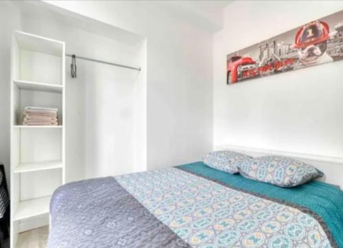 une chambre avec un lit avec une couette bleue dans l'établissement Basilique VII, à Douvres-la-Délivrande