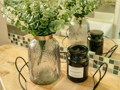 a vase with flowers in it on a counter with a bottle of wine at Prestwick Lodge in Clarens