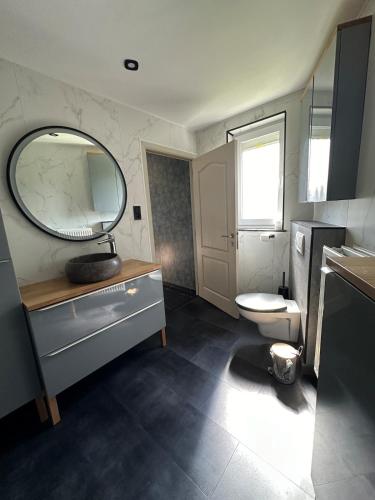 a bathroom with a sink and a toilet and a mirror at THE120 work or holiday home in Comines