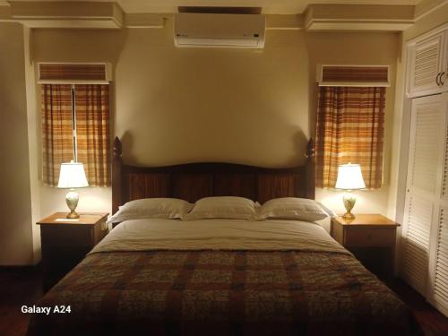 a bedroom with a large bed with two lamps on tables at Yap Pacific Dive Resort in Yaptown