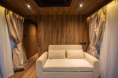 a white couch in a room with wooden walls at Timber Society Boutique Hideaway in Phuket Town