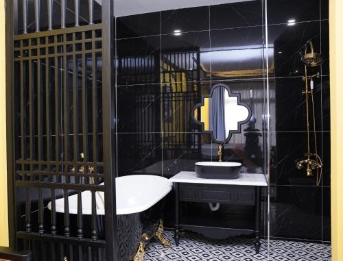 a black bathroom with a sink and a mirror at New Pearl Hotel in Ho Chi Minh City