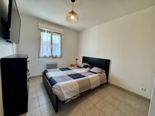 une chambre avec un lit et une télévision à écran plat dans l'établissement Maison 3 chambres avec jardin et spa, aux Arcs-sur-Argens