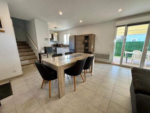 une cuisine et une salle à manger avec une table et des chaises en bois dans l'établissement Maison 3 chambres avec jardin et spa, aux Arcs-sur-Argens