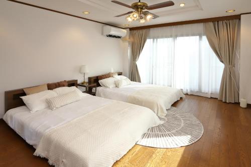 a bedroom with two beds and a ceiling fan at 野田離宮 in Osaka