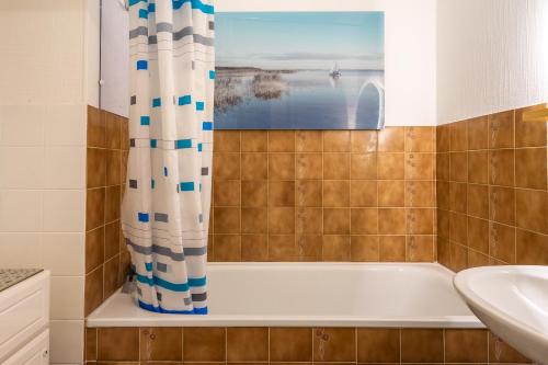 a bathroom with a tub and a sink at Le Pré Catelan in Saint-Georges-de-Didonne