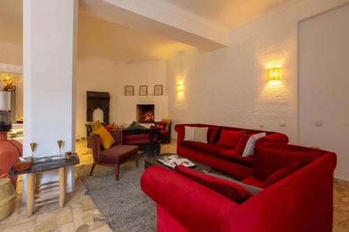 a living room with red couches and a fireplace at Charming 5 bedroom in Marrakech