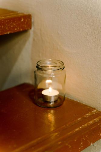 a candle in a glass jar on a table at Duke Oasis in Kuala Lumpur