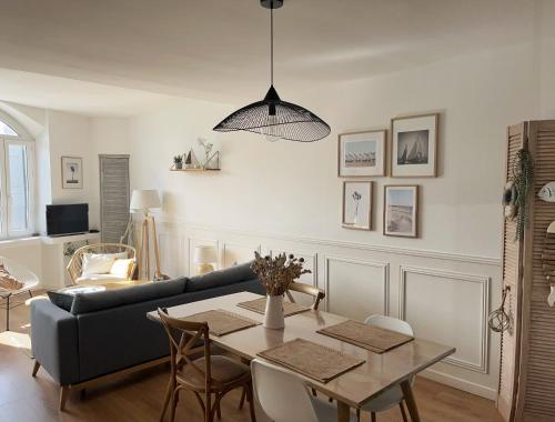 a living room with a table and a couch at Le Carnet de Sète et sa vue sur le canal in Sète