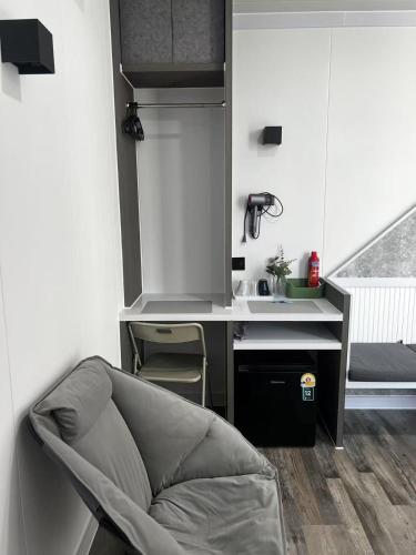 a kitchen with a sink and a chair in a room at Coolplay house in Bangkok